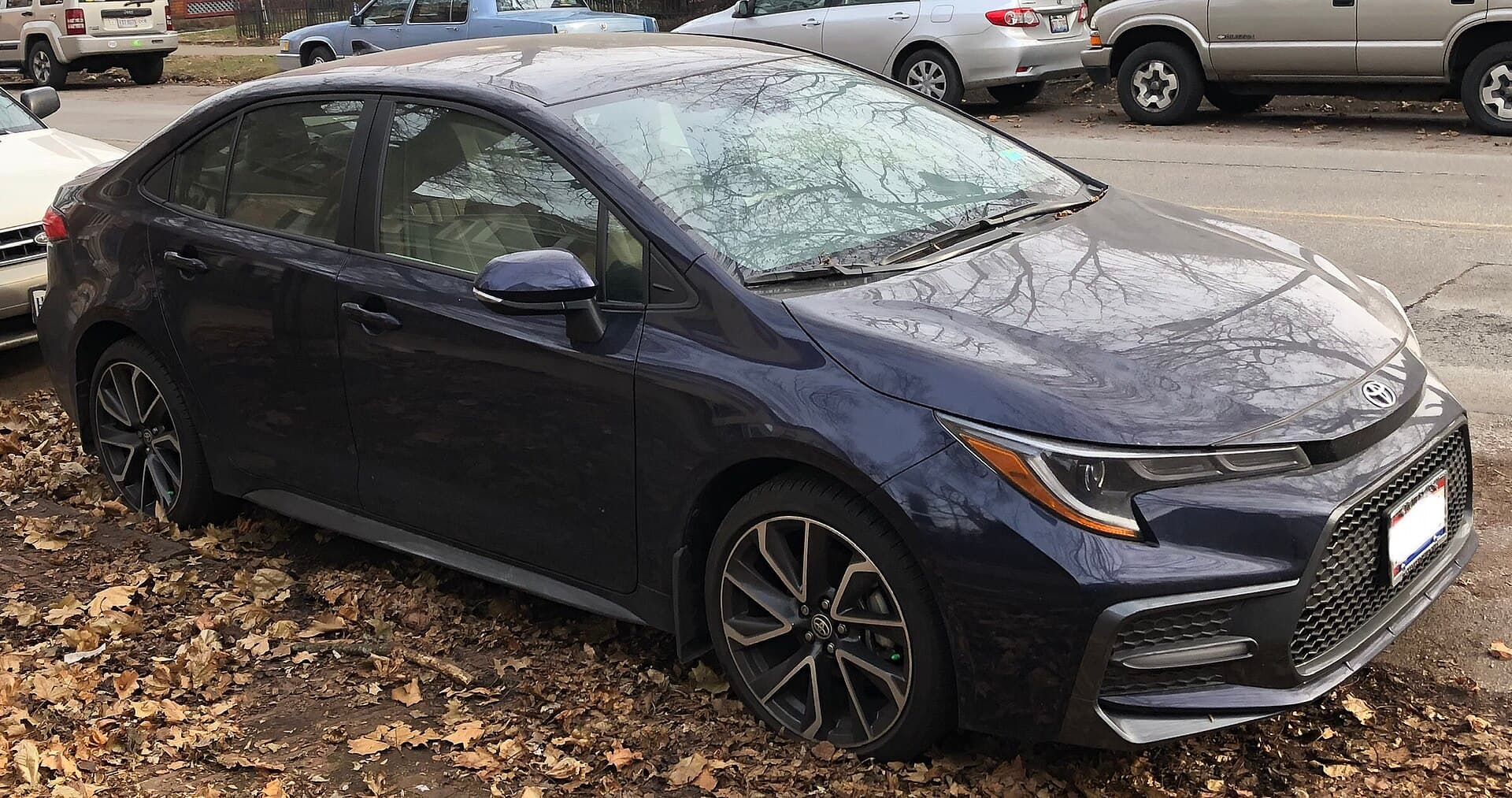 Dark blue 2020 Toyota Corolla SE sedan parked on a leaf-covered verge
