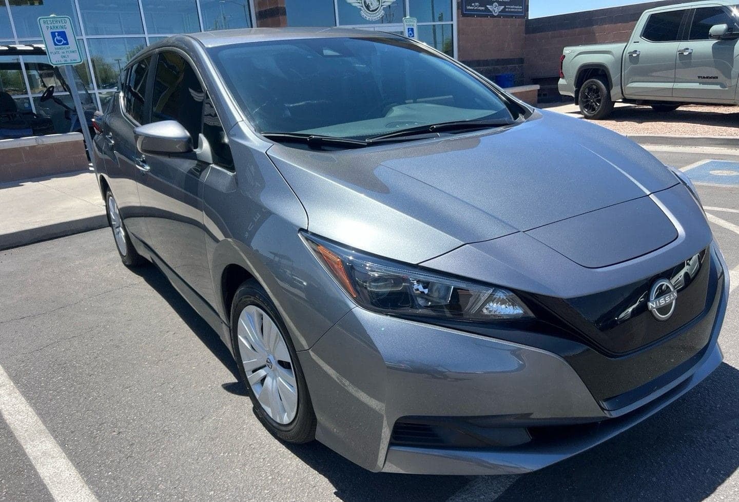 Grey 2023 Nissan Leaf in a dealership lot, seen from the front quarter